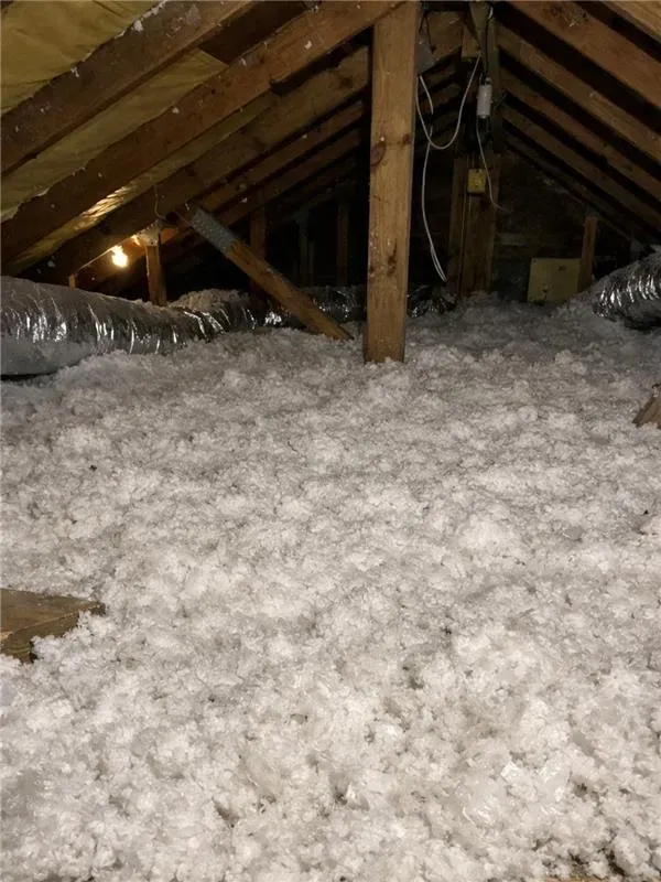 Professional attic assessment showing HVAC ductwork and existing insulation